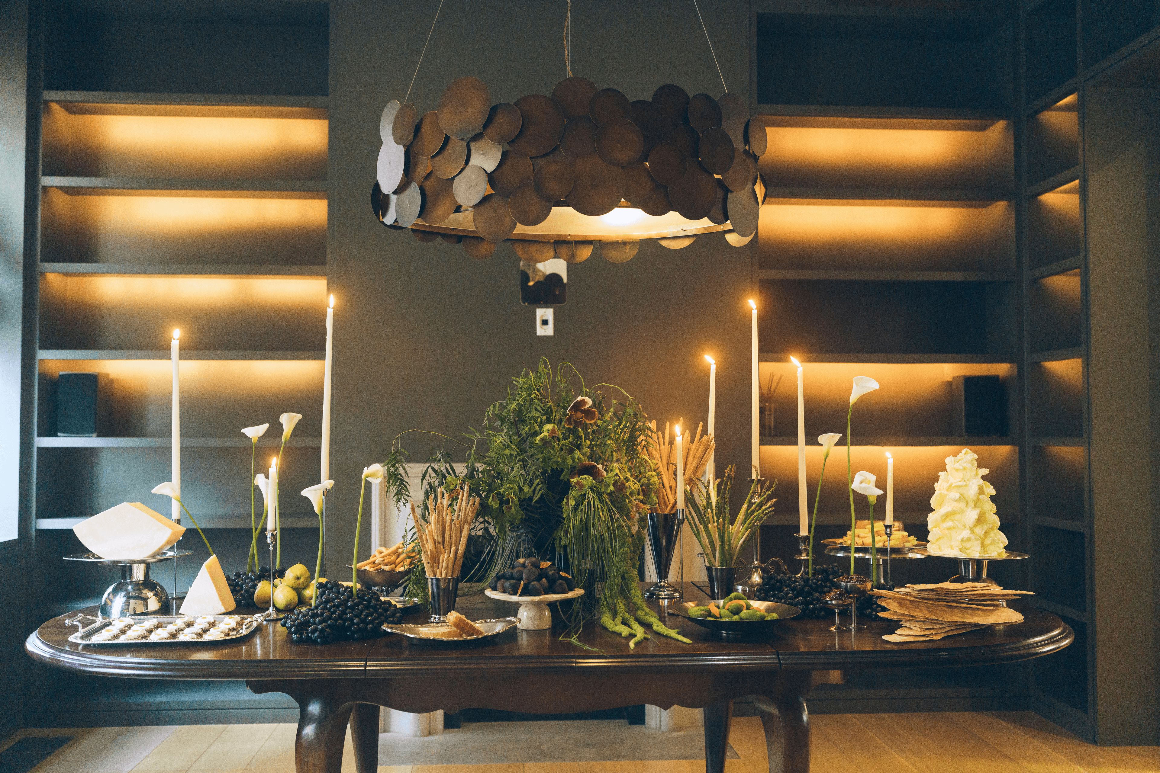 An intimate table set with candles, florals, and seasonal food